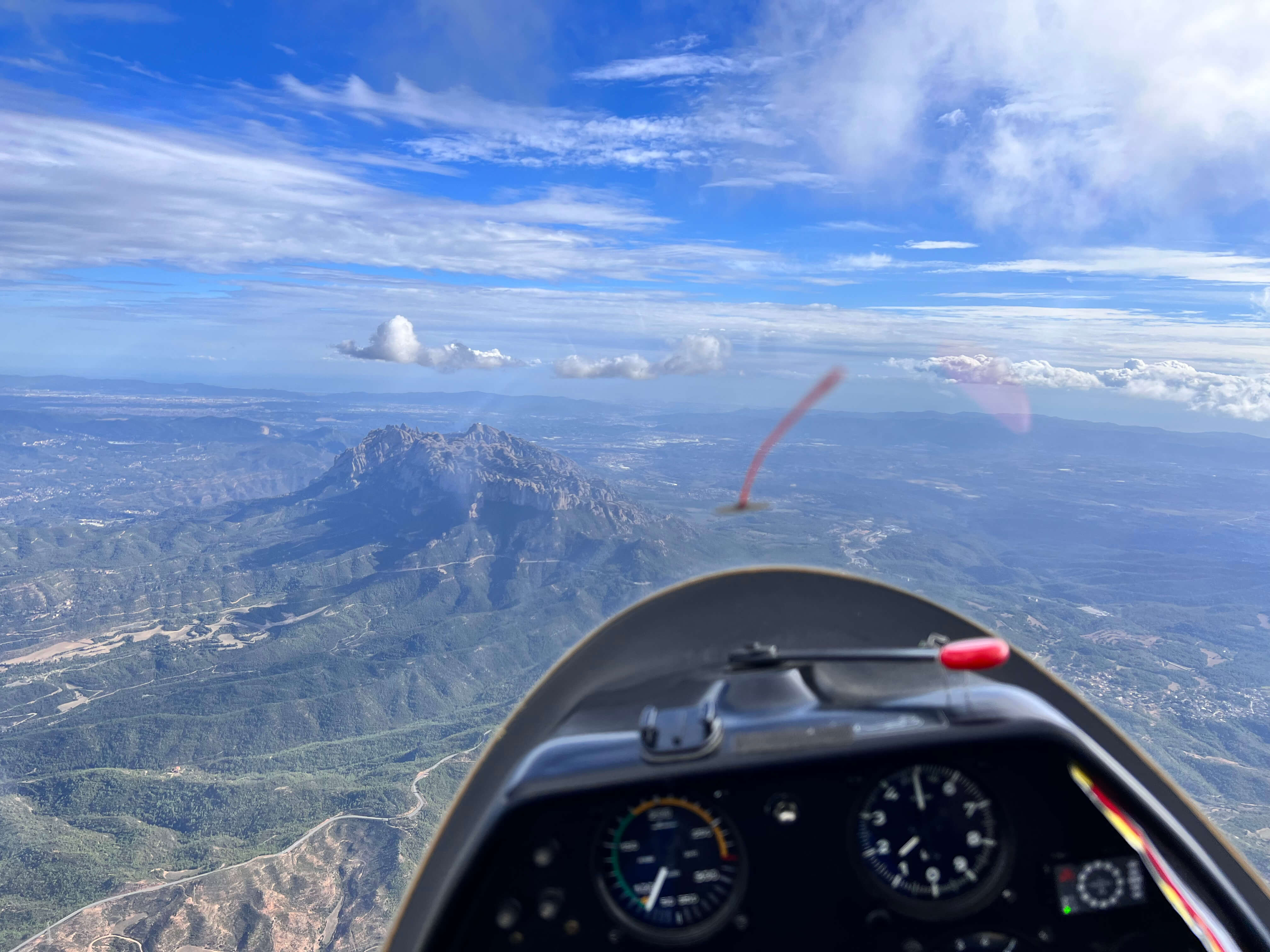 Planeador volando sobre paisaje montañoso